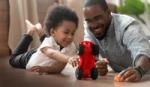 Boy and father playing with toy car