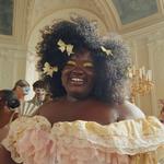 A woman wearing a ruffled pastel dress in an ornate ballroom. Dove has collaborated with Netflix series Bridgerton.